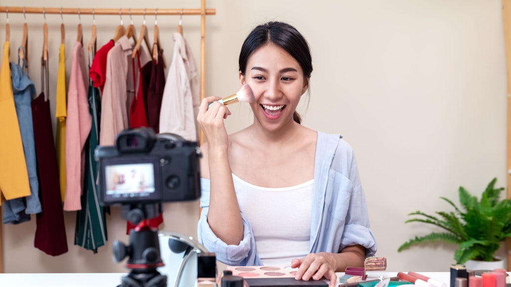 Portrait Or Headshot Of Attractive Young Asian Influencer, Beauty Blogger, Content Creator Or Vlogger Girl Review Make Up Looking At Camera At Home. Asian Woman Using Internet For Tutorial Li portret van een jonge vrouwelijke influencer
